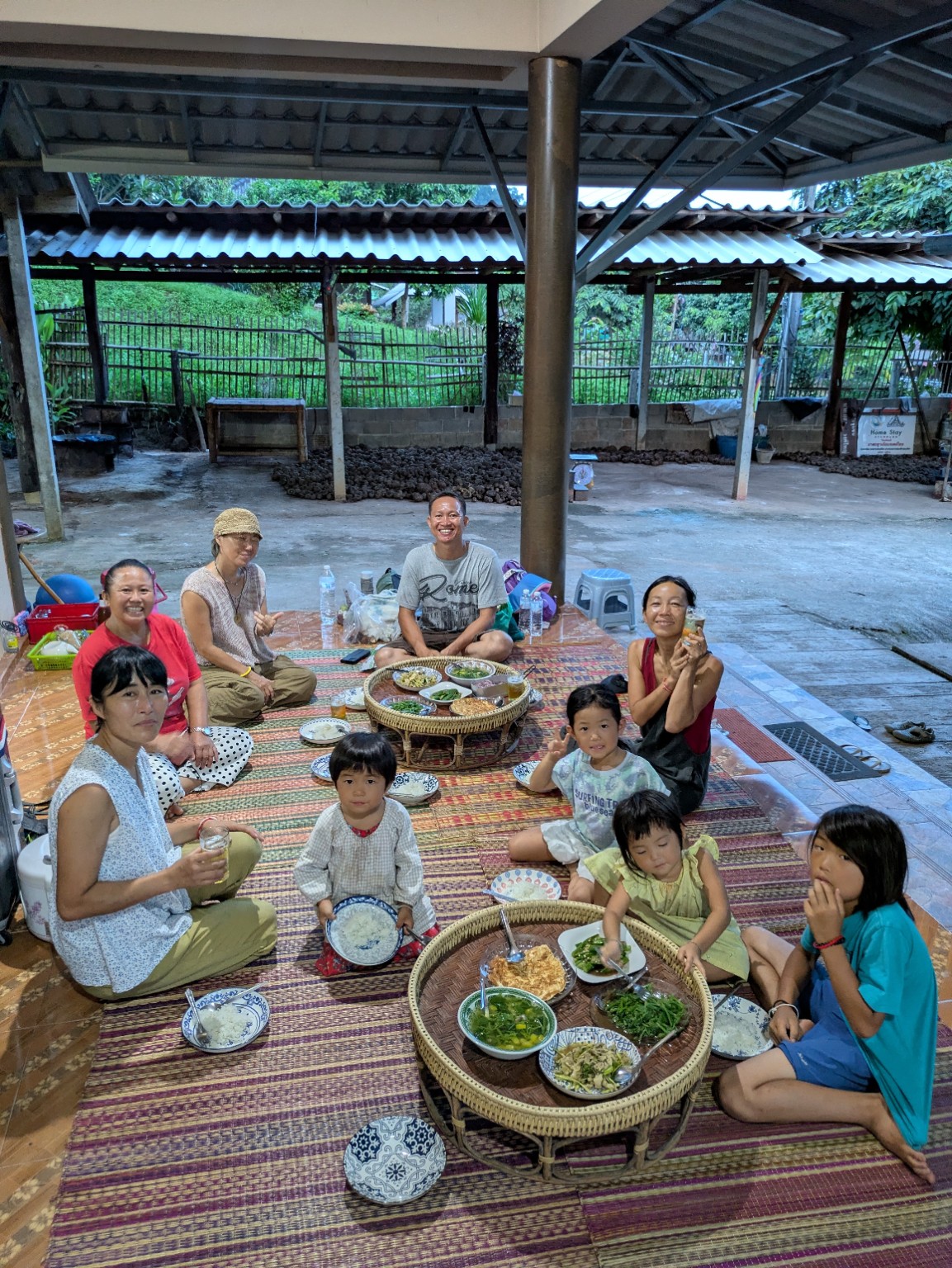 村のみなさんと料理を囲む家族